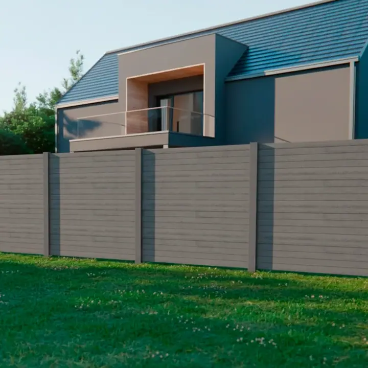 Precast concrete wall in grey Urban closing off a garden, seen from a distance