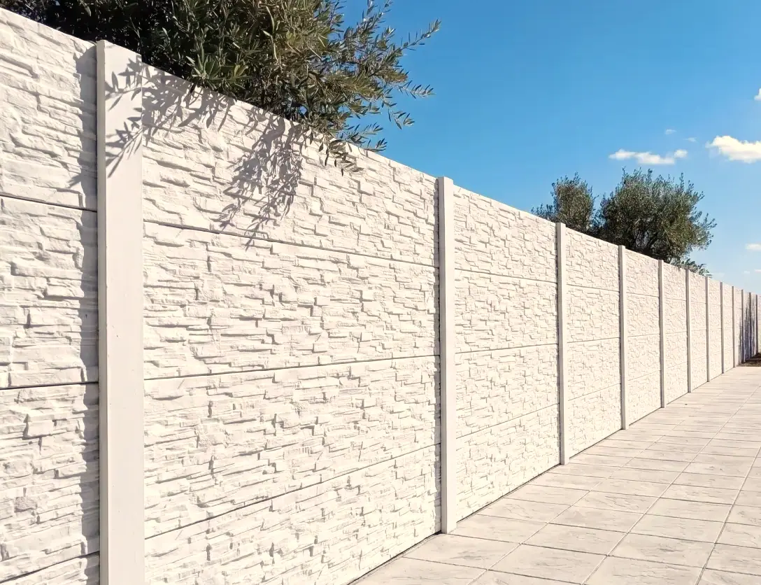 White concrete wall with Alpine stone texture along a path lined with olive trees